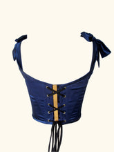 Load image into Gallery viewer, A back view of the Anna stays. The back neckline scoops down. The lacing has a blue silk placket behind it. The placket ribbon holds the lacing in place and is gold.