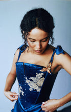 Load image into Gallery viewer, A side front shot of a woman in the Anna stays. The neckline is decoared on the left side with gold ribbon flowers and leaves tipped with pearls