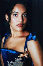 Load image into Gallery viewer, A close up image of a woman in the blue silk Anna stays. The neckline scoops up, and the gold ribbon and lace details contrast with the deep blue fabric.