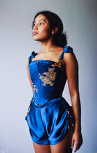 Load image into Gallery viewer, A photo of a woman wearing the Anna stays and tap pants. The blue of both matches and both are deccorated with pearls and gold ribbon.