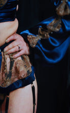Load image into Gallery viewer, A close up of the Anna Suspender belt and cuff of the sleeve. The sleeve silk and lace drapes generously over the wrist.