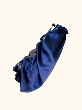 Load image into Gallery viewer, A side product view of the Anna sleeve. The sleeve drapes down in a bell sleeve shape. The top seam has a gold lace insert, which puffs out in between pearls and gold ring inserts.