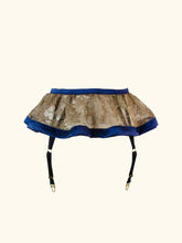 Load image into Gallery viewer, A back view of the Anna Suspender belt. The waistband is covered in blue silk and matches the hem band. The delicate gold lace is a floral pattern.