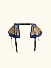 Load image into Gallery viewer, A front product image of the Anna suspender. the front edges of the lace are trimmed in narrow blue silk and the hem in a deeper band.