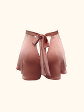 Load image into Gallery viewer, A back view of the Sarah tap pants on a stand. Showing the bow fastening and the way the silk flares out from the waist over the hips. The pink is dusky and natural.