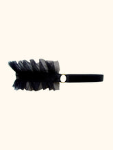 Load image into Gallery viewer, The side view of a black frilled choker with a central black satin elastic band. The front frilled portion joins to a gold ring, in turn the ring joins to the back adjustable strap.