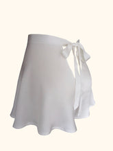 Load image into Gallery viewer, The side back view of the ivory sandwashed silk Emmeline tap pants. The back fastens with a bow that extends from the waistband and is around 1 inch wide. There is a small triangular gap below the bow that would expose the lower back. The fabric is bias cut and flows down over the hips to the top of the thigh. The fabric is generously cut and folds gently as it falls.