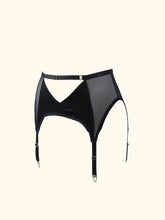 Load image into Gallery viewer, The front of the Win suspender belt. The belt has 4 straps and gold hardware. The front panels are silk and cross over to create an inverted triangle cut out below the waist. An adjustable waistband strap runs above this.
