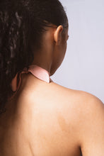 Load image into Gallery viewer, A view of the halter strap at the back of the Sarah bralette, it is tied in a bow peeping out from under the model's dark curly hair.