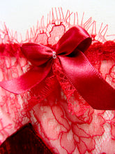 Load image into Gallery viewer, A close up of the deep red bow on the hipline of the knickers. It has two small, clear glass beads sewn into the centre and is layered with red lace. The ribbon has a satin finish.