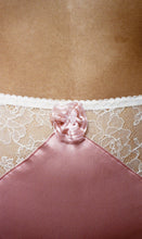 Load image into Gallery viewer, A close up on the pink rosette at the front of the knickers. It is gathered into a circular frill with pink beads in the centre.