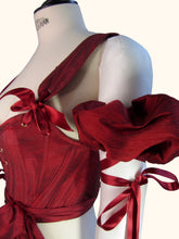 Load image into Gallery viewer, A close up of the sleeve with the Olenska Stays. This shows the ribbon tied higher up the arm with long trailing ribbons. The ribbons on the stays and sleeves match.