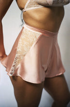 Load image into Gallery viewer, A model wears the Sarah tap pants. This side view shows the inverted triangle panel of lace at the side of the tap pants, it is around 4 inches wide at the waistband, and half an inch wide at the hem. The waistband is around 1 inch wide and sits on the waist.