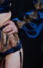 Load image into Gallery viewer, A close up of the Anna Suspender belt and cuff of the sleeve. The sleeve silk and lace drapes generously over the wrist.
