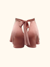 Cargar imagen en el visor de la galería, A back view of the Sarah tap pants on a stand. Showing the bow fastening and the way the silk flares out from the waist over the hips. The pink is dusky and natural.
