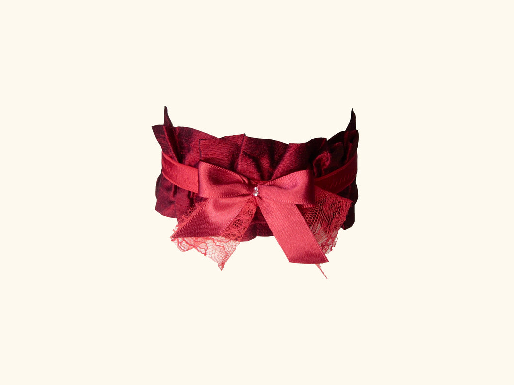 Dark red ruffled choker with a lace trimmed bow and beads at the front