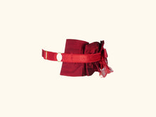 Load image into Gallery viewer, side view of dark red garter. The ruffles extend half way round the neck. The back is red lingerie elastic with gold hardwear.
