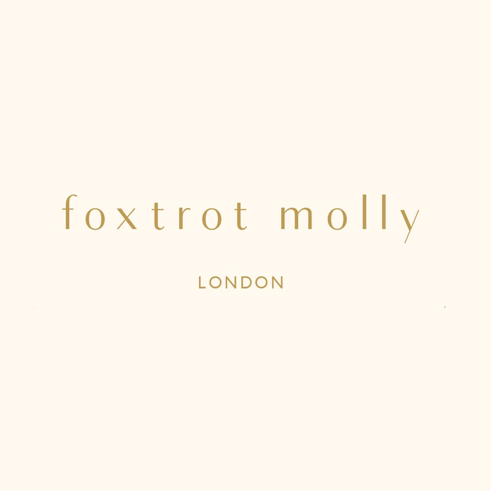 The Foxtrot Molly logo. Gold text on a warm cream background.