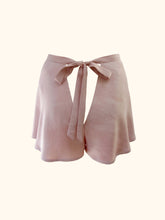 Cargar imagen en el visor de la galería, The back of the avocado bamboo tap pants on a stand. They fasten at the back with a bow that extends out of the waistband and is around 1 inch wide. There is a triangular gap below the bow which would expose the lower back. The pink is a dusky, natural and warm tone.
