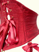 Load image into Gallery viewer, A closeup of the back of the corset belt. The eyelets are gold as are the ribbon lacing tips. The grain of the silk runs around the body.
