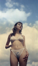 Charger l&#39;image dans la galerie, A woman stands outside against a blue sky with white clouds, she wears the Lily bralette and knickers which mirror the colours in the sky.

