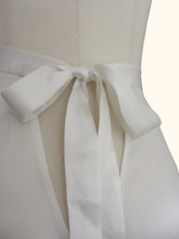 Cargar imagen en el visor de la galería, Close up of the bow fastening of the ivory sandwashed Emmeline tap pants on a stand. Showing the matte nature of the silk and the v shaped gap beneath the bow.
