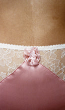 Load image into Gallery viewer, A close up on the pink rosette at the front of the knickers. It is gathered into a circular frill with pink beads in the centre.
